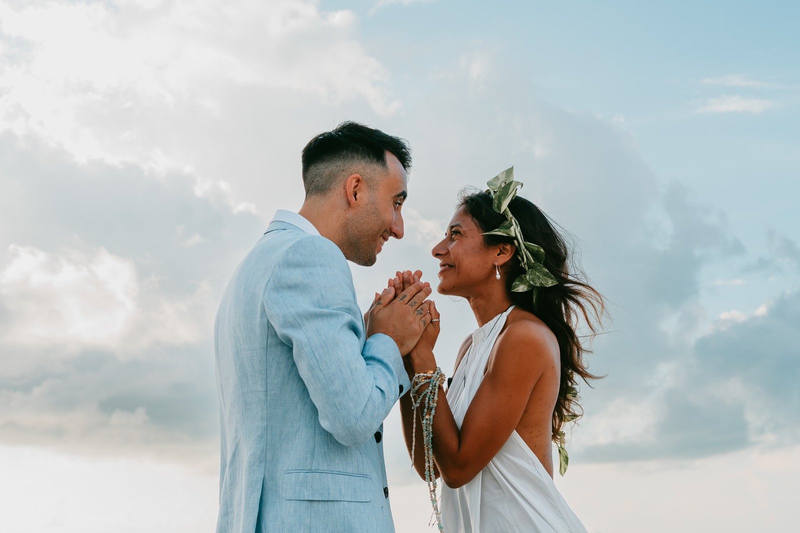 Pareja mirándose y sosteniéndose las manos durante una ceremonia al aire libre